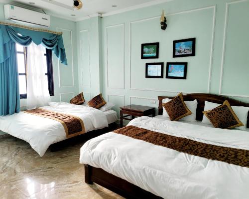 two beds in a room with blue walls at Ma Pi Leng Hotel in Dồng Văn