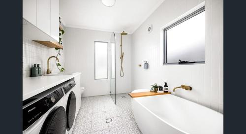 a white bathroom with a tub and a sink at The South bay's home-Small RoomB in Sydney