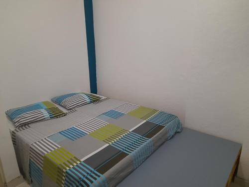 uma cama num canto de um quarto em Appartement T3 Cœur De Ville Patio em Fort-de-France