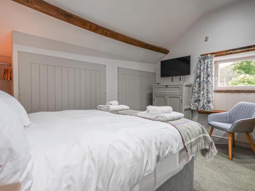 a bedroom with a large white bed and a television at Walnut Cottage - Uk43995 in Fairfield