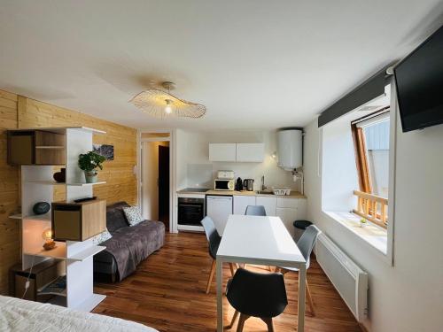 Ce petit appartement comprend une table et une cuisine. dans l'établissement Studio charmant avec parking et vue montagne - FR-1-608-251, à Le Mont-Dore