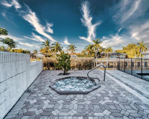 un bain à remous sur une terrasse avec une clôture dans l'établissement Waterfront Villa Heated Pool Spa Walk To Beach, à Fort Lauderdale