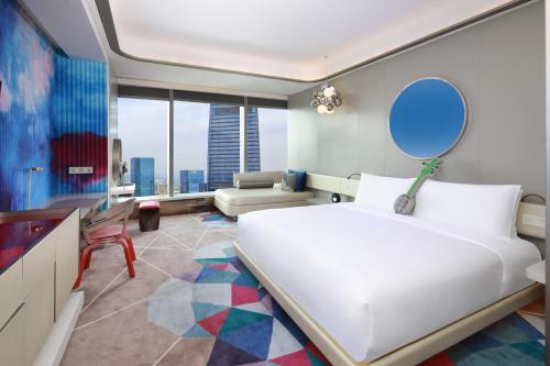 a bedroom with a large white bed and a mirror at W Suzhou - Jinji Lake in Suzhou