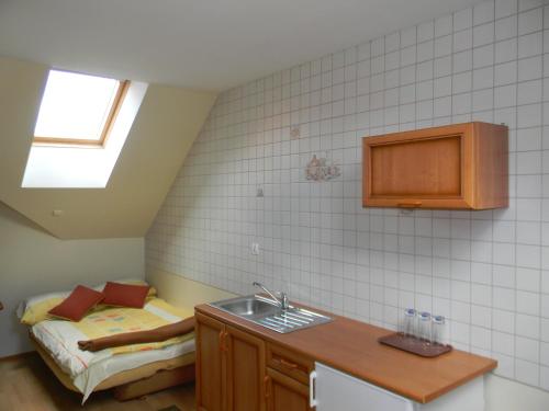eine kleine Küche mit einem Waschbecken und einem Bett in der Unterkunft Prohibicja Peter's Pub in Mikołajki