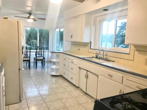 a kitchen with white cabinets and a table and chairs at Rooms in Monterey Park CA in Monterey Park