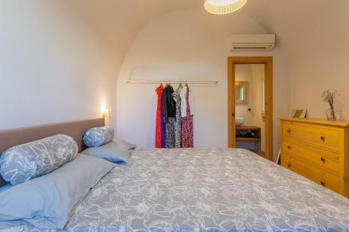 a bedroom with a bed with blue pillows and a dresser at IL Marinaretto in Giovinazzo