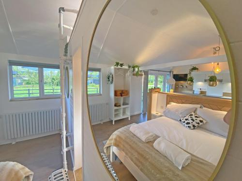 a bedroom with a bed and a mirror at The Little Barn in Hoxne