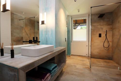uma casa de banho com um lavatório branco e um chuveiro em BohoStyleApartment am See em Schluchsee