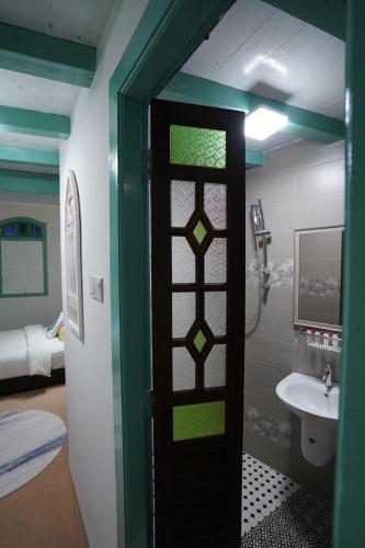 a bathroom with a glass door with a sink at Le Meilleur in George Town