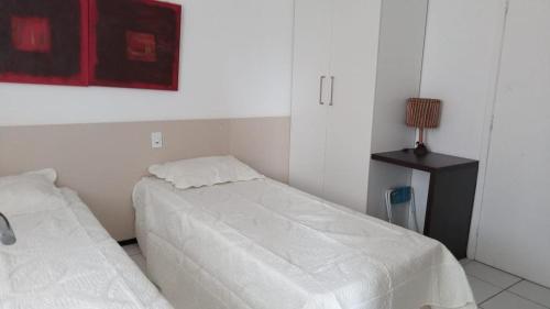 una camera da letto con due letti e un tavolo con una lampada di Gran solare Lençois (flat) a Barreirinhas