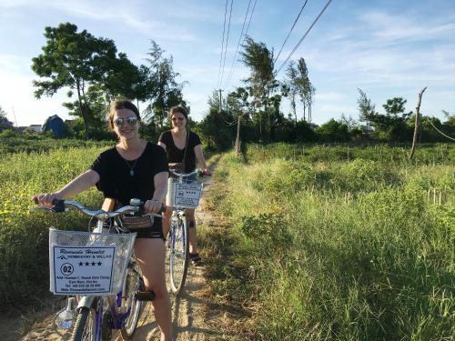 two women riding bikes on a dirt trail at Riverside Hamlet Homestay & Villa in Hoi An