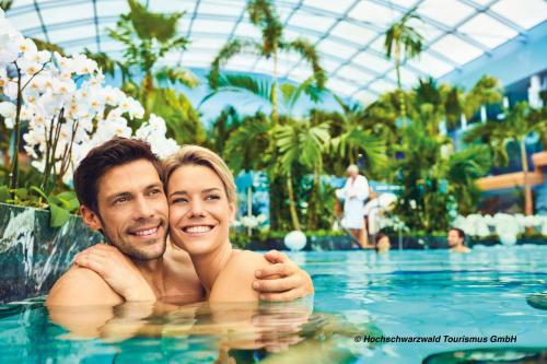un uomo e una donna in una piscina di BohoStyleApartment am See a Schluchsee