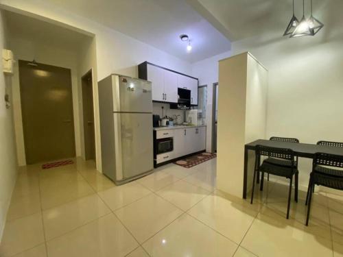 a kitchen with a table and a stainless steel refrigerator at Condo with pool-Muslim friendly in Kuala Lumpur