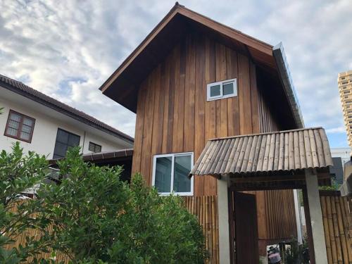 a wooden house with a gambrel roof at Wooden house in the centre of Chiangmai self-checkin in Chiang Mai