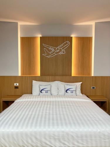 a bedroom with a bed with a white comforter at Air Diamond Hotel in Ban Nong Khong