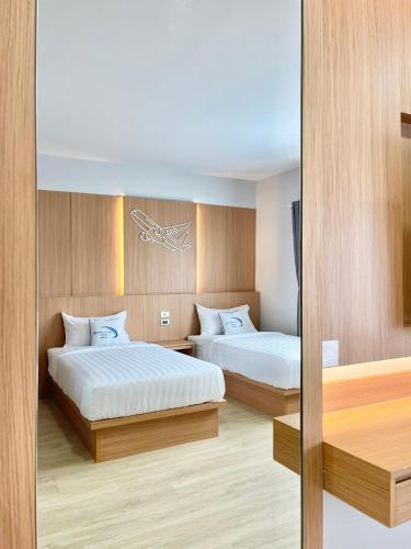 a hotel room with two beds and a mirror at Air Diamond Hotel in Ban Nong Khong