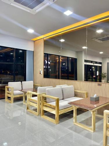 a lobby with a couch and tables and windows at Air Diamond Hotel in Ban Nong Khong