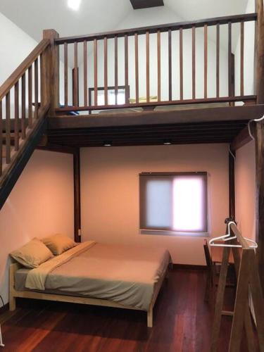 Un dormitorio con una litera y una escalera. en Wooden house in the centre of Chiangmai self-checkin, en Chiang Mai