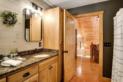 La salle de bains est pourvue d'un lavabo et d'un miroir. dans l'établissement Nearwcuwififirepitgrilllg Porch5 Star Clean!, à Sylva