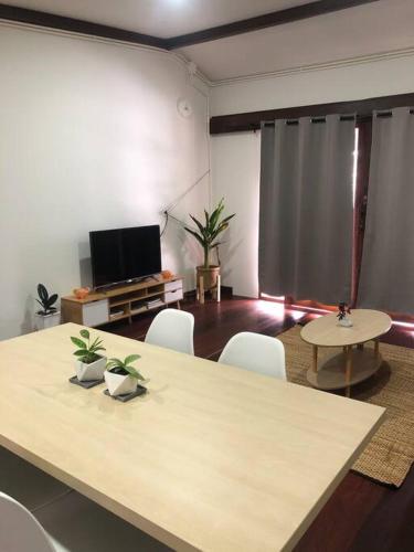 a room with a table and chairs and a television at Wooden house in the centre of Chiangmai self-checkin in Chiang Mai