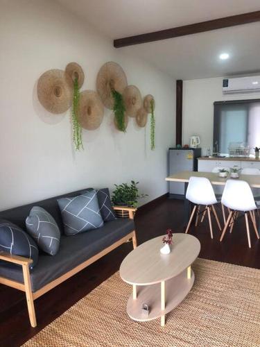 a living room with a couch and a table at Wooden house in the centre of Chiangmai self-checkin in Chiang Mai