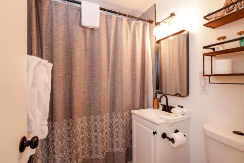 ein Badezimmer mit Duschvorhang und Waschbecken in der Unterkunft The Eagles Nest Hot Tub BBQ Modern Retreat in Sugarloaf