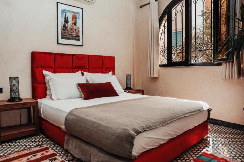a bedroom with a large bed with a red headboard at Auberge RIAD DLIM Tamraght in Tamraght Ouzdar
