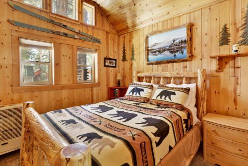 ビッグ・ベアー・レイクにあるMoonridge R n R- Cozy Single Level Central Chalet Homeの丸太小屋のベッドのある寝室