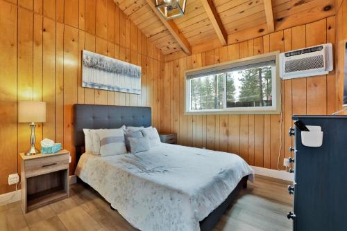 a bedroom with a bed in a wooden wall at Sweet Retreat 1- Cozy Relaxing Resort Cabin in Big Bear Lake