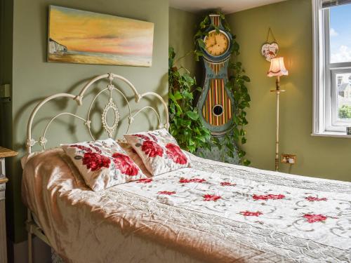 a bedroom with a bed with a clock on the wall at The Epple Bay Retreat in Birchington