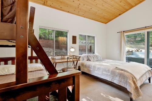 une chambre avec un lit, un bureau et des fenêtres dans l'établissement Knickerbocker Retreat- Hot Tub- Game Tables, à Big Bear Lake