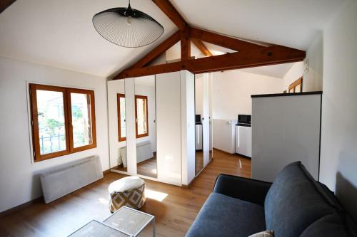 uma sala de estar com um sofá e uma mesa em Studio * Confort * Sérénité * La halte du Pèlerin em Bures-sur-Yvette
