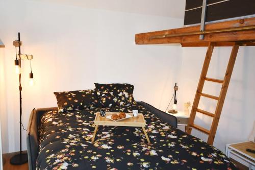 a bedroom with a bed with a table on it at Studio * Confort * Sérénité * La halte du Pèlerin in Bures-sur-Yvette
