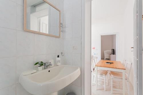 ein weißes Badezimmer mit einem Waschbecken und einem Tisch in der Unterkunft Casa Bianca bnb Big Terrace 10min Airport, Beach in Bitonto