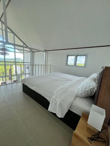 a bedroom with a large bed and a table at บ้านภูไผ่ ไร่ภูไผ่เบิกตะวัน in Ban Nam Phang