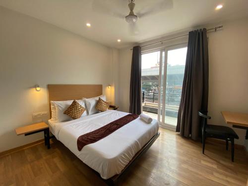 a bedroom with a large bed and a large window at F9 Hotels 343 Meera Bagh, Paschim Vihar in New Delhi