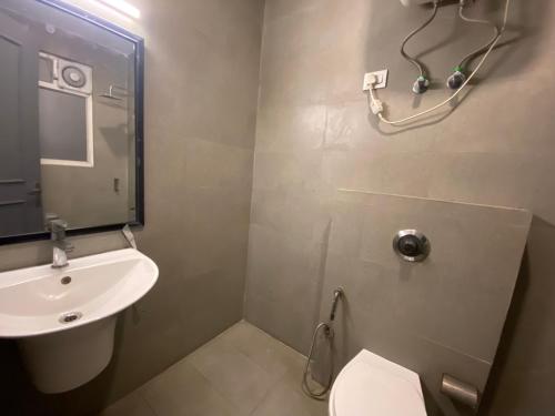 uma casa de banho com um lavatório, um WC e um espelho. em F9 Hotels 343 Meera Bagh, Paschim Vihar em Nova Deli