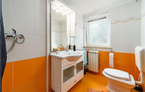 an orange and white bathroom with a sink and a toilet at 4 Bedroom Stunning Home In Jurani in Ružići