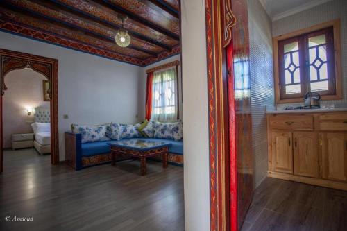 - un salon avec un canapé bleu et des fenêtres dans l'établissement Guest House Yasmina, à Chefchaouen