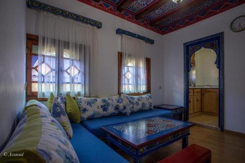 - un salon avec un canapé bleu et une table dans l'établissement Guest House Yasmina, à Chefchaouen