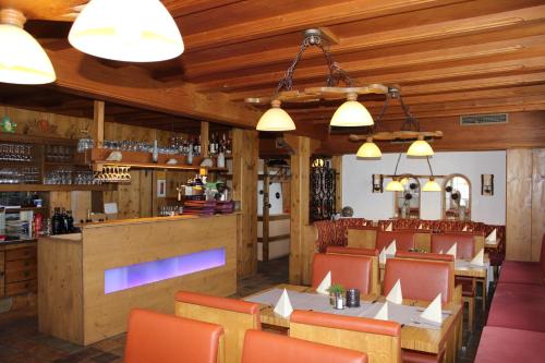 ein Restaurant mit einem Tisch und Stühlen sowie einer Bar in der Unterkunft Ristorante Pizzeria Pension Taormina in Roßhaupten