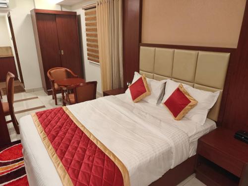 a bedroom with a large bed with red pillows at Hotel Newline Orchid in Guruvāyūr