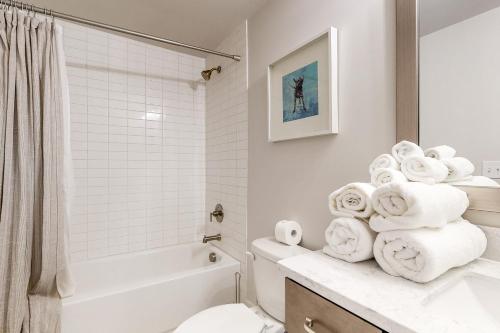 a white bathroom with a toilet and a sink and towels at In the Heart of the City in Marietta