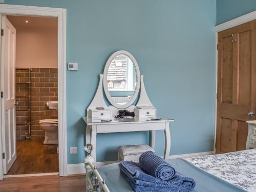 1 dormitorio con paredes azules y espejo en St, Georges Cottage en Holmfirth