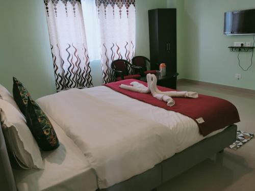 Un dormitorio con una cama con dos animales. en Hotel BJ en Gangtok