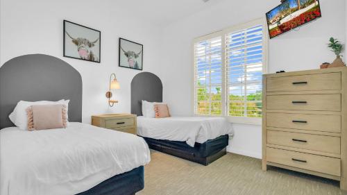 a bedroom with two beds and a dresser and a window at LV204 Airy Upstairs 2 Bedroom w Private Balcony in La Quinta