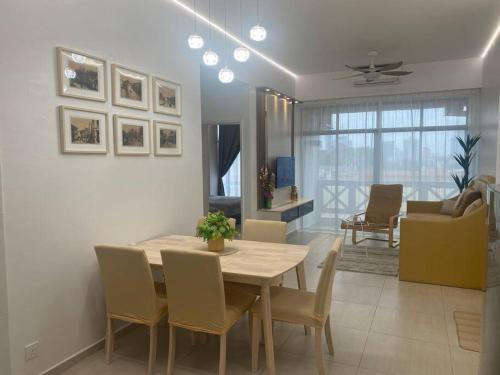 einen Esstisch und Stühle im Wohnzimmer in der Unterkunft My Cozy 2-bedroom Apartment in Malakka