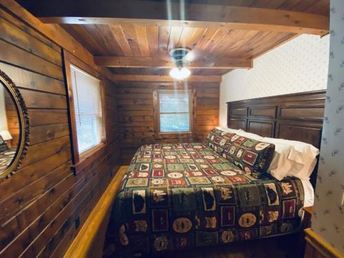 1 dormitorio con 1 cama en una cabaña de madera en Cozy Cabin at Bear Mountain Log Cabins, en Eureka Springs