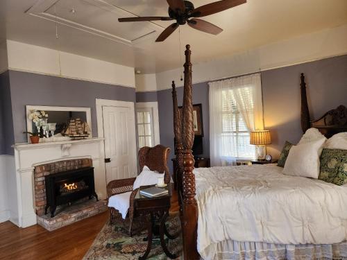 ein Schlafzimmer mit einem Bett und einem Kamin in der Unterkunft Rosemont B&B Cottages in Little Rock