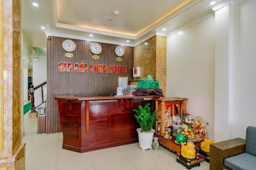 um lobby com um balcão com relógios na parede em Gia Cat Long Hotel em Ilha de Cát Bà